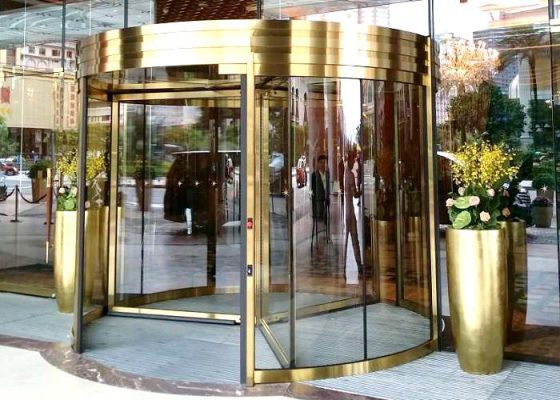 Mẫu cửa xoay tự động thiết kế mạ vàng sang chảnh đặt tại tiền sảnh trung tâm thương mại lớn Mẫu cửa xoay tự động thiết kế mạ vàng sang chảnh đặt tại tiền sảnh trung tâm thương mại lớn